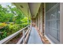 Covered porch with white railing, brick accents, and view of landscaped yard with mature trees at 3549 Dogwood Dr, Powder Springs, GA 30127