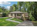 Inviting exterior view features a well-kept lawn, stone walkway, quaint front porch, and unique elevated bonus room at 2156 Doris Dr, Decatur, GA 30034