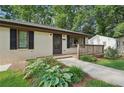Close up exterior showing stone walkway, well kept grass and foliage, freshly painted brick and a cozy front porch at 2156 Doris Dr, Decatur, GA 30034