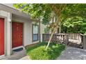 Townhome entrance featuring a red door, green shrubs, and a stone walkway leading up to the home at 807 Woodcliff Dr, Sandy Springs, GA 30350