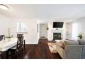 Open concept living room featuring hardwood floors, fireplace, kitchen access, and dining area at 807 Woodcliff Dr, Sandy Springs, GA 30350