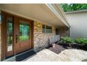 Welcoming front entrance with a stone facade, wood door, and manicured landscaping at 1665 Chevron Way, Sandy Springs, GA 30350