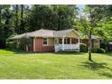 Attractive brick home with a white porch and landscaped front yard showcasing curb appeal at 1865 Briarlake Cir, Decatur, GA 30033