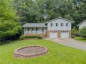 Inviting home with manicured lawn, brick accents, two-car garage, and lovely covered front porch at 5841 Covered Wagon Trl, Lilburn, GA 30047