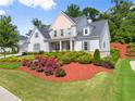 Charming two-story home featuring a lush lawn and beautiful landscaping at 5875 Windjammer Pt, Cumming, GA 30041