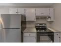 Well-equipped kitchen with stainless steel refrigerator, oven, granite countertops, and modern cabinets at 8541 Westchester Dr, Douglasville, GA 30134
