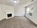 Bright living room with a fireplace, carpet flooring, and plenty of natural light at 7007 Setters Way, Lithonia, GA 30038