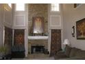 Elegant living room with a stone fireplace, high ceilings, and decorative art at 3643 Fowler Rdg, Douglasville, GA 30135