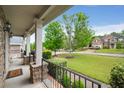 Inviting front porch with stone pillars, black railings, and green landscaping at 4415 Saint Andrews Crest Dr, Cumming, GA 30040
