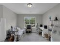 This carpeted bedroom includes a futon sofa, a desk and chair set, and a window allowing natural light at 6820 Gallant Se Cir # 2, Mableton, GA 30126