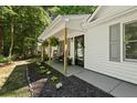 Inviting covered porch adorned with hanging plants, a cozy bench, and fresh landscaping at 121 Danielle Ct, Villa Rica, GA 30180
