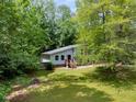 View of home with gray siding through trees and a green yard at 1741 Branch View Dr, Marietta, GA 30062