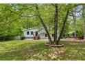 Charming gray home with stone accents and wooden porch, surrounded by lush green trees and a well-maintained yard at 1741 Branch View Dr, Marietta, GA 30062