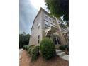 Three-story townhouse with well-manicured bushes, a cozy front porch, and neutral siding at 790 Village Field Ct, Suwanee, GA 30024
