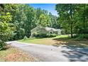 Secluded one-story house surrounded by abundant trees and greenery, accessed by a paved driveway at 1294 Red Rock Rd, Acworth, GA 30101