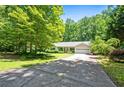 One-story home with a covered front porch and attached two-car garage surrounded by lush greenery at 1294 Red Rock Rd, Acworth, GA 30101