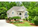 Inviting two-story facade with mature trees, well-maintained lawn, and a welcoming entrance with a charming walkway at 10490 Cranchester Way, Alpharetta, GA 30022