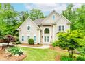 Elegant home with manicured lawn, bench, and double door entrance with beautiful decorations at 10490 Cranchester Way, Alpharetta, GA 30022