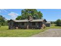 Well-maintained brick home with an established lawn, complemented by fresh flowerbeds and a detached storage building at 14721 Highway 36, Covington, GA 30014