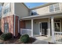 Charming entrance with a covered porch, featuring brick accents and a freshly painted front door, inviting guests inside at 2114 Woodland Ln, Alpharetta, GA 30009