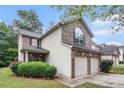 A charming home with a brick front, a two-car garage, and beautiful green landscaping at 6664 Saint Jude Dr, Fairburn, GA 30213