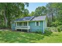 View of light green house featuring a cozy front porch and tidy, green lawn at 100 Davis Mill N Rd, Dallas, GA 30157