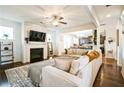 Cozy living room featuring a fireplace, ceiling fan, and open access to the kitchen at 2496 Osceola Rd, Lithonia, GA 30058