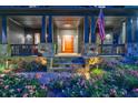 Inviting front porch featuring stone accents, blue pillars, stylish front door, and beautifully landscaped flower beds at 3117 W Roxboro Ne Rd, Atlanta, GA 30324