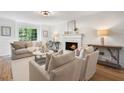 Elegant living room featuring a fireplace, large windows, and stylish furniture, perfect for relaxation and entertaining guests at 3214 Woodleaf Ct, Marietta, GA 30062