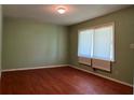 Bedroom featuring hardwood floors, neutral green walls and a large window at 4048 Emerald Lake Dr, Decatur, GA 30035