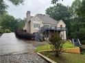 View of the home's rear, showing a spacious wooden deck overlooking the backyard at 1640 Settindown Dr, Roswell, GA 30075