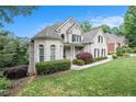 Beautiful home exterior featuring well-maintained landscaping, white brick, and a spacious front yard at 1640 Settindown Dr, Roswell, GA 30075
