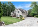 Elegant home with lush lawn, extensive driveway, white brick facade, and professionally landscaped yard at 1640 Settindown Dr, Roswell, GA 30075