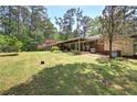Large, shady backyard featuring a covered patio and mature landscaping, ideal for relaxation at 3156 Pope Rd, Douglasville, GA 30135