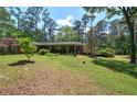 Expansive backyard with lush green grass and a covered patio area, perfect for outdoor entertaining at 3156 Pope Rd, Douglasville, GA 30135