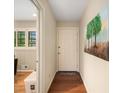 Hallway with hardwood floors, white door, and artwork; opens to an office with bright, shuttered windows at 2556 Defoors Ferry Nw Rd, Atlanta, GA 30318