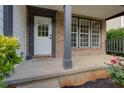 Inviting front porch features brick accents, neutral trim, and a well-manicured garden at 3260 Ridgefair Dr, Cumming, GA 30040