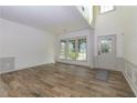Open concept living room with wood-look floors, chair rail, and a window-filled front entrance at 3260 Ridgefair Dr, Cumming, GA 30040