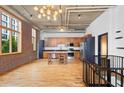 Open kitchen with stainless steel appliances, wood cabinets, a dining table, exposed brick, and a modern chandelier at 660 Glen Iris Dr # 206 & 109, Atlanta, GA 30308