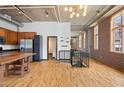 Bright, open living room with hardwood floors, exposed brick and ductwork, concrete ceilings, and kitchen at 660 Glen Iris Dr # 206 & 109, Atlanta, GA 30308