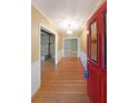 Inviting foyer with hardwood floors and a decorative front door with red trim and stained glass at 1001 Wiley Bridge Rd, Woodstock, GA 30188