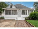 Inviting white home with a screened-in porch and brick-lined walkway leading to the entrance at 1796 Center Ave, East Point, GA 30344