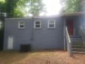 Rear exterior of the home with gray siding and steps up to the back entrance at 2835 Burton Rd, Atlanta, GA 30311