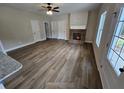Spacious living room featuring a brick fireplace, ceiling fan, and multiple windows for natural light at 42 Woodhaven Path, Rockmart, GA 30153