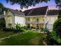 Expansive backyard with a multi-tiered deck, a stone patio, and beautifully landscaped garden beds at twilight at 450 Bay Grove Se Rd, Loganville, GA 30052