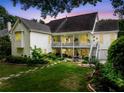 Expansive backyard with lush lawn, landscaping, patio, and covered porch at dusk at 450 Bay Grove Se Rd, Loganville, GA 30052