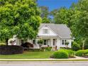 Charming traditional home featuring a manicured lawn, lush landscaping, and a welcoming front porch at 450 Bay Grove Se Rd, Loganville, GA 30052