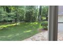 A serene backyard offers ample green space, framed by mature trees visible through the window at 50 Stonington Pl, Marietta, GA 30068