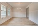 Elegant dining room with wainscoting, light wood floors, neutral paint, and plenty of natural light at 105 Bre Dr, Fayetteville, GA 30215