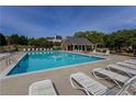 Community swimming pool with lounge chairs and a nearby covered area at 1365 Juniper Springs Trl, Loganville, GA 30052